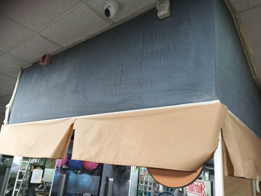 Pared gris con manchas y desperfectos durante la preparación para pintar
