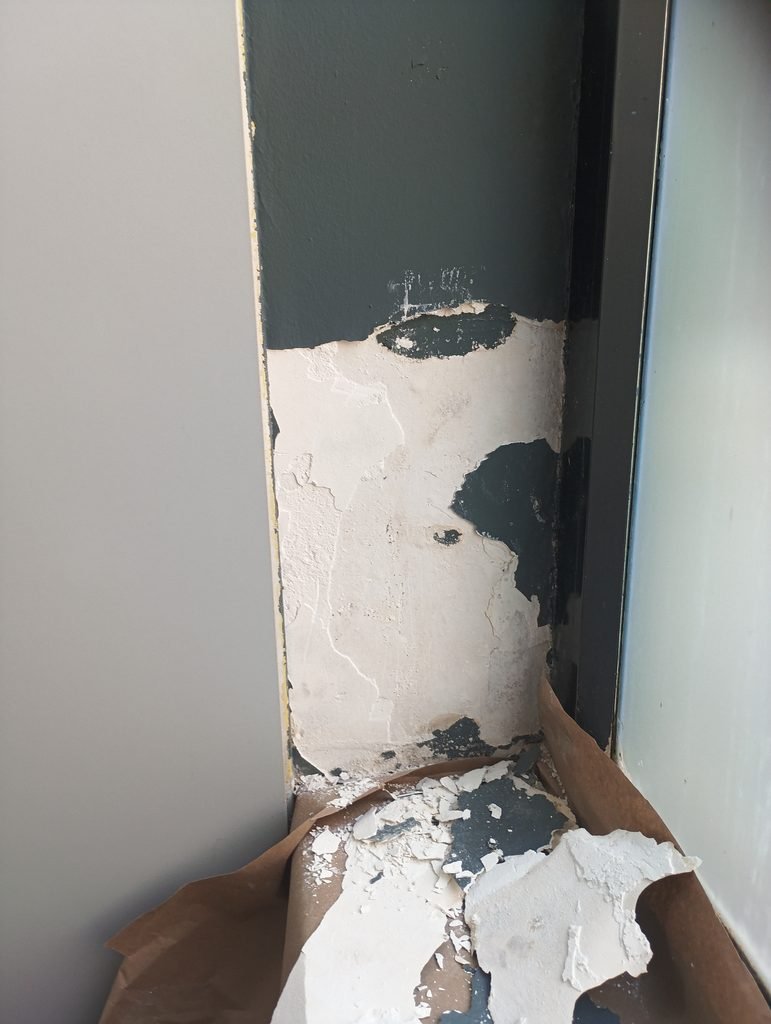 Pared con pintura desprendida antes de reparar con yeso
